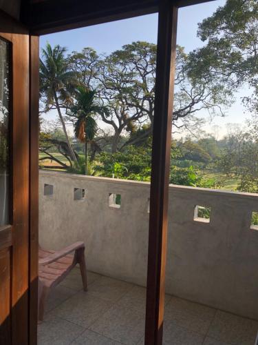 a view from a window of a balcony with a bench at senarathna guest house in Weligama