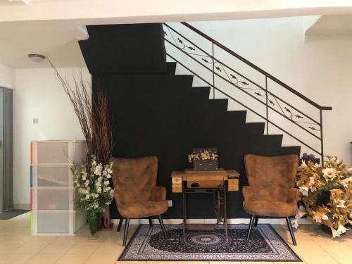 a room with two chairs and a desk and stairs at Homestay Country Homes Rawang in Rawang