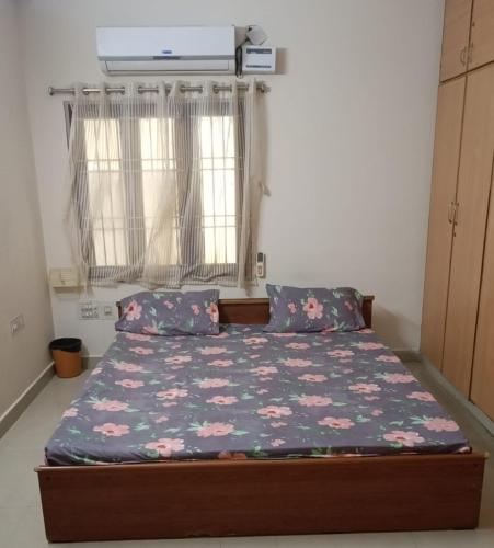 a small bedroom with a bed with flowers on it at HARI HARAN in Nellore