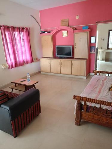 uma sala de estar com uma cama, um sofá e uma televisão em HARI HARAN em Nellore
