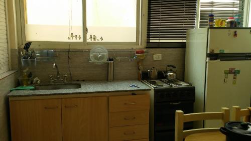 a kitchen with a sink and a stove and a refrigerator at Guidi in Mar del Plata