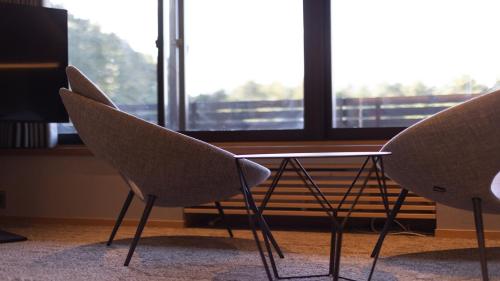 two chairs and a table in front of a window at Sengokubara COCON in Hakone