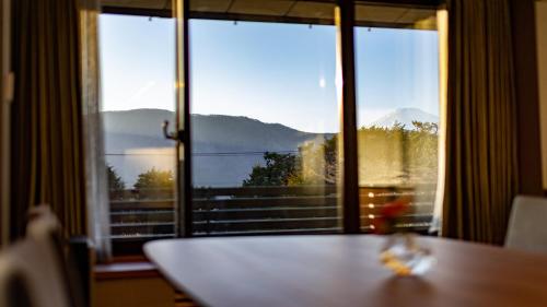 a table with a view of a mountain view from a window at Sengokubara COCON in Hakone