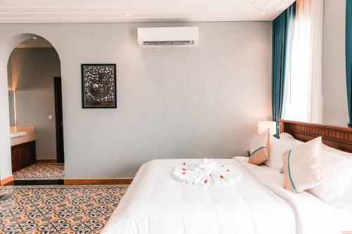 a bedroom with a white bed and a window at Sokchea Kampot Hotel in Kampot