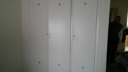 a man standing next to a row of white cabinets at Guidi in Mar del Plata