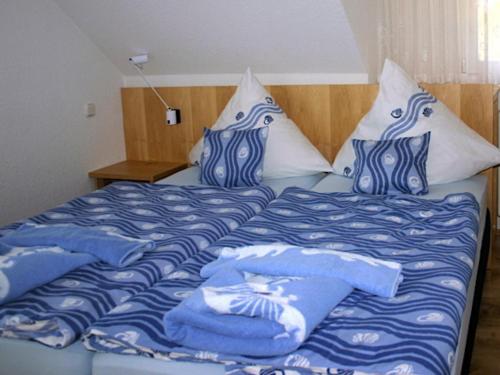 Cama con sábanas y almohadas azules y blancas en Ferienwohnung auf Hiddensee im Ort Kloster en Kloster