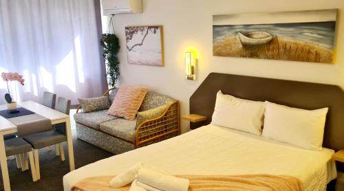 Habitación de hotel con cama y sofá en Golden Sands Motor Inn, en Forster