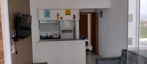 eine kleine Küche mit einer Theke und einem Kühlschrank in der Unterkunft Apto familiar c/ piscina, próx as praias reg Sul in João Pessoa