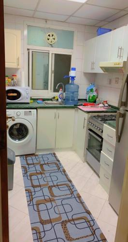 a kitchen with a sink and a stove top oven at marena in Ajman 