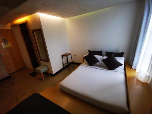 a bedroom with a large white bed with black pillows at Urban Boutique Hotel in Boracay