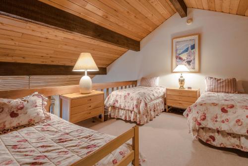 Sunburst Condo 2789 - Room for Up To 11 Guests and Elkhorn Resort Amenities في Elkhorn Village: غرفة نوم بسريرين وسقف خشبي