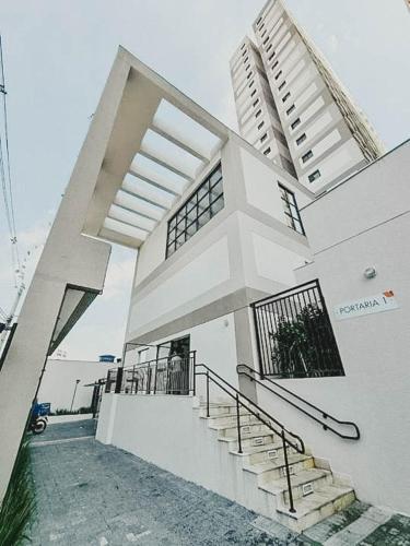 a large white house with stairs in front of it at Lindo Apartamento - 15 min de Pinheiros in Osasco