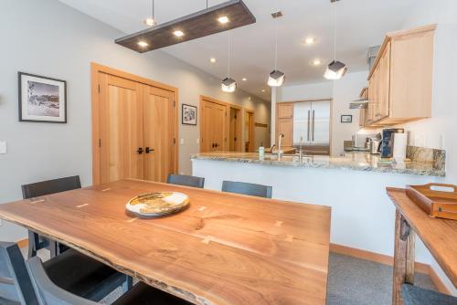 Il comprend une cuisine et une salle à manger avec une table en bois. dans l'établissement Snowstar Condo 23 - Walk to Town and Ski Lifts, à Ketchum