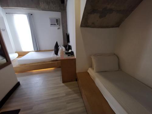 a small room with a bed and a window at Urban Boutique Hotel in Boracay