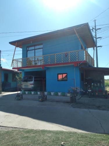 a blue building with a balcony on top of it at Angel's Homestay 