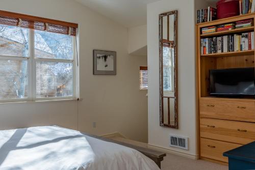- une chambre avec un lit, une télévision et une étagère dans l'établissement Sunbird Condos 9 - Walk to Downtown Ketchum & Bald Mountain, à Ketchum