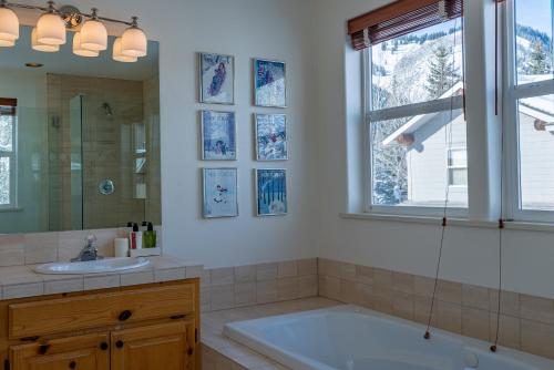 La salle de bains est pourvue d'une baignoire, d'un lavabo et d'un miroir. dans l'établissement Sunbird Condos 9 - Walk to Downtown Ketchum & Bald Mountain, à Ketchum