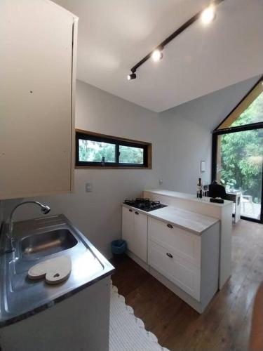 uma cozinha com um lavatório e uma bancada em Chalé da Colina Florianópolis em Florianópolis