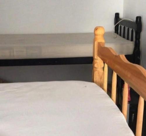a bedroom with a bed and a table with a window at B & B HOSTEL Coqueiros in Florianópolis