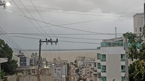 a group of birds sitting on power lines in a city at B & B HOSTEL Coqueiros in Florianópolis