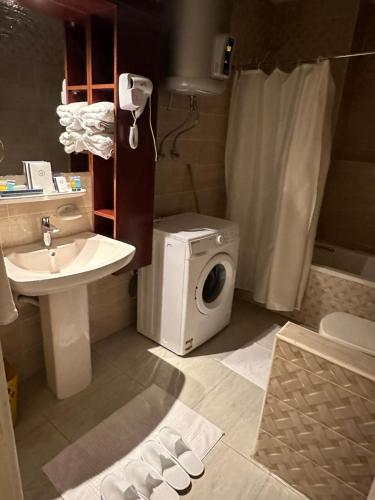 a bathroom with a washing machine and a sink at شقة مفروشة فاخرة مطلة على كورنيش النيل المعادي بالطابق 23 in Cairo