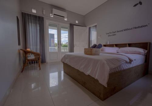 a bedroom with a large bed and a balcony at Villa Palm Springs by REQhome in Ciater-hilir