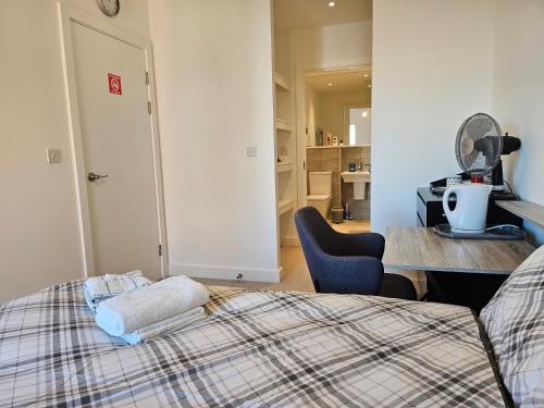 a bedroom with a bed and a desk and a chair at Stylish Ensuite Double-Bed with Desk in Barking