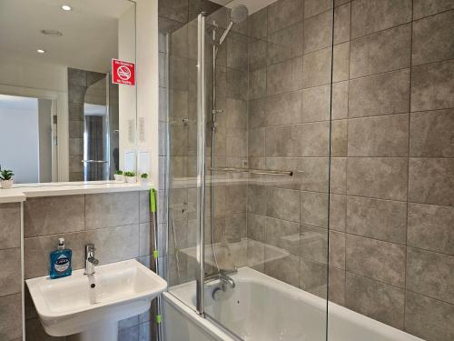 a bathroom with a shower and a sink at Stylish Ensuite Double-Bed with Desk in Barking