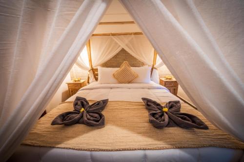 a bed in a tent with two bows on it at Villa WES - Legian - 5 Bedroom - 4 Bath - Location in Seminyak