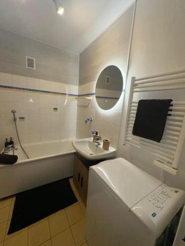 une salle de bain avec un lavabo, une baignoire et des toilettes dans l'établissement Studio « Le petit montagnard », à Malbuisson