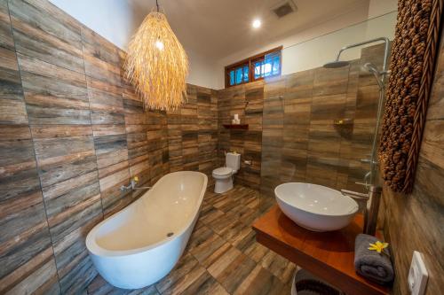 a bathroom with a tub and a toilet and a sink at Villa WES - Legian - 5 Bedroom - 4 Bath - Location in Seminyak