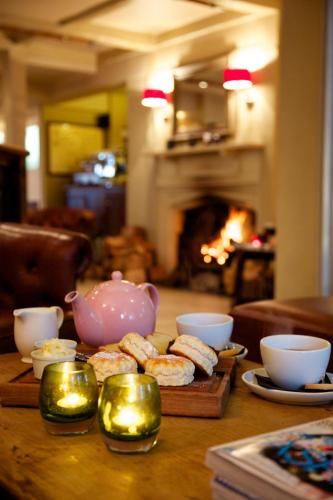 a table with a tea pot and cookies on it at Mercure Thame Lambert Hotel in Chinnor