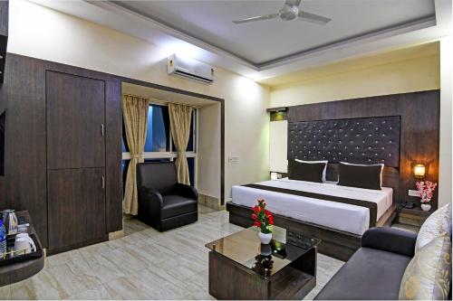 een hotelkamer met een bed en een bank bij Townhouse Hotel Refresh in Calcutta