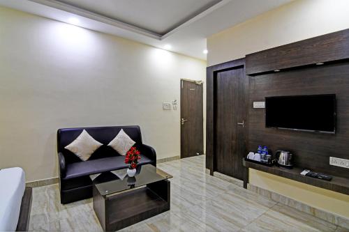 a living room with a couch and a tv at Townhouse Hotel Refresh in Kolkata