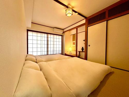 a large white bed in a room with a window at LoveTokyo Maisonette Terrace in Tokyo
