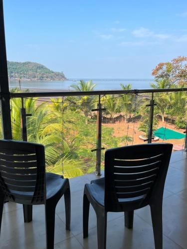 a balcony with two chairs and a view of the ocean at Sea Bliss Resort in Kolthare