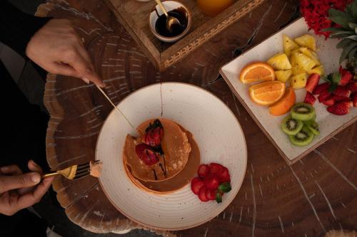 Una persona está comiendo un tazón de mantequilla de maní y fruta. en Casa Concreto- 5-Bedroom Luxury Villa with all weather Pool, en Jodhpur