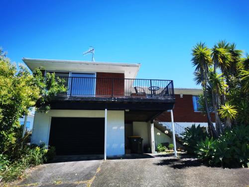 a house with a balcony with a garage at Sunshine hillcrest home in Auckland