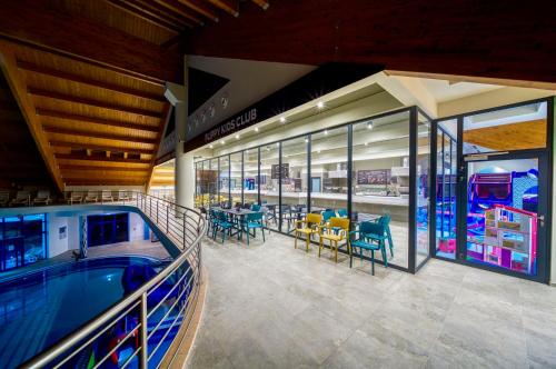 a shopping mall with a pool and tables and chairs at Wellness Hotel Patince in Patince
