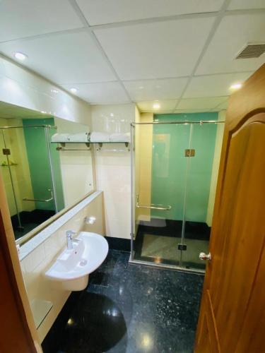 a bathroom with a sink and a glass shower at Peppervine Hotel in Thekkady