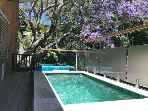 a swimming pool with a tree in the background at Tree Top Rest - Bright Water Retreat in Bundeena