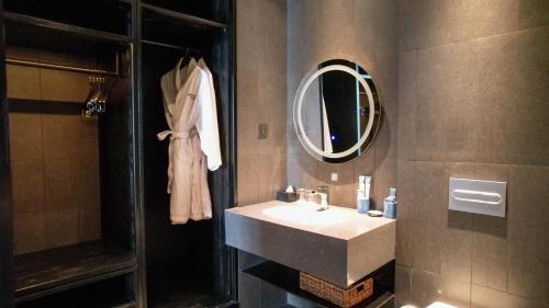 Grand ASTON Puncak Hotel & Resort في بونشاك: حمام مع حوض ومرآة