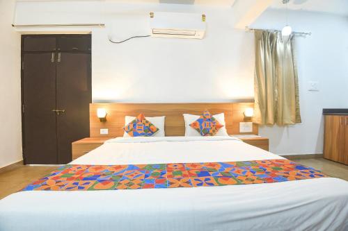ein Schlafzimmer mit einem großen Bett mit einer bunten Bettdecke in der Unterkunft FabExpress Holiday Suites in Benaulim