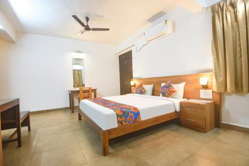 una camera da letto con un letto, una scrivania e un letto sidx sidx sidx di FabExpress Holiday Suites - Nr Benaulim Beach a Benaulim