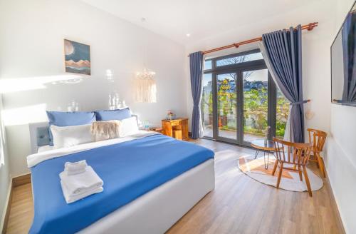 ダラットにあるBoho Boutique Dalat Hotel & Apartmentのベッドルーム(青と白のベッド1台、テーブル付)