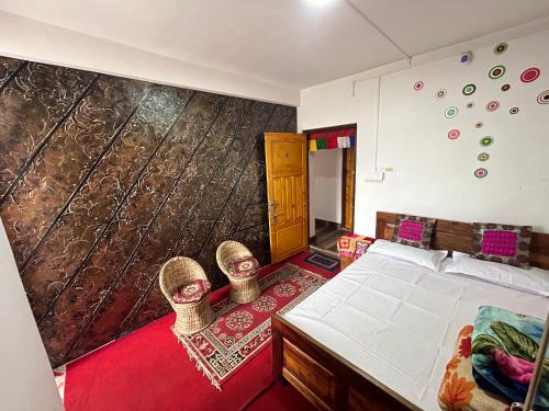 um quarto com uma cama e uma grande parede em Kunsang Homestay em Ghum