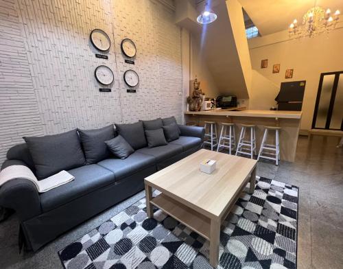 a living room with a blue couch and a table at 4 Bedroom House with Beautiful Rooftop near BTS Ekkamai in Bangkok