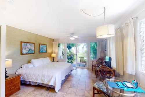 a bedroom with a bed and a table and chairs at Kapa`a Sands 18 in Kapaa