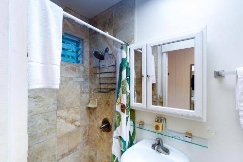 a bathroom with a sink and a shower with a mirror at Kapa`a Sands 18 in Kapaa