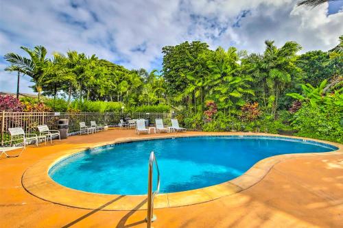 a swimming pool in a resort with chairs and trees at Kapa`a Sands 18 in Kapaa